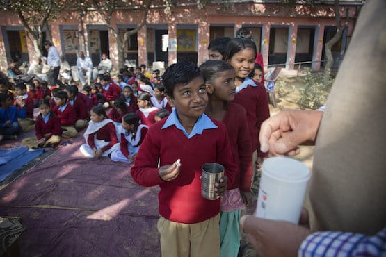 Children waiting in line for Evidence Action deworming pills