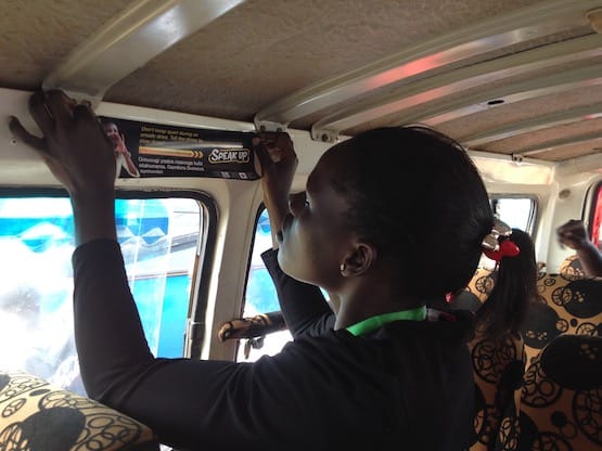 Woman placing Zusha sticker in bus