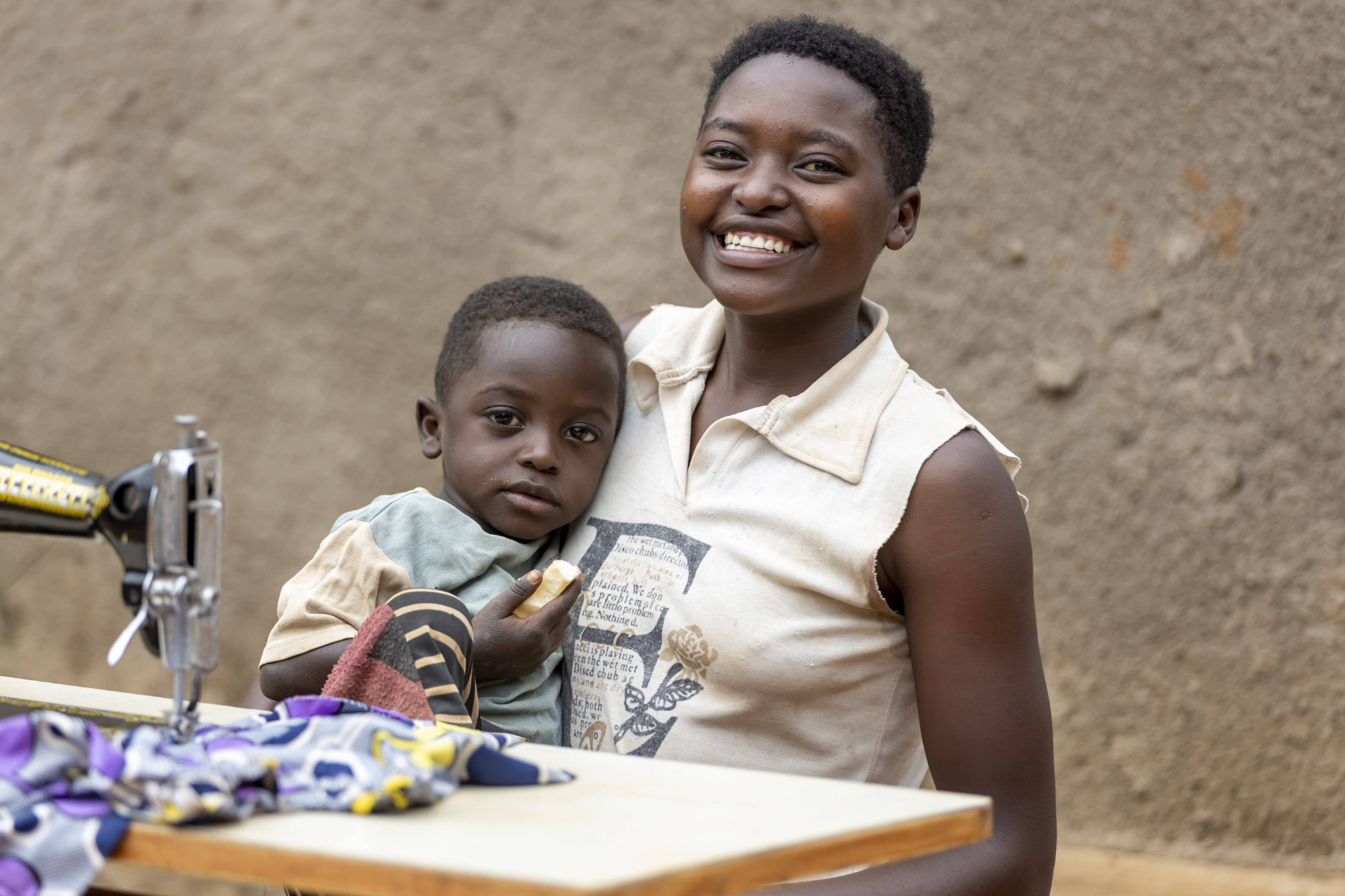 Francoise, Rwanda, a girl sewing with a young child